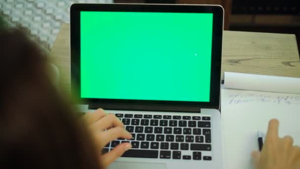 Vrouw te typen op een laptopcomputer met een key groen scherm. — Stockvideo