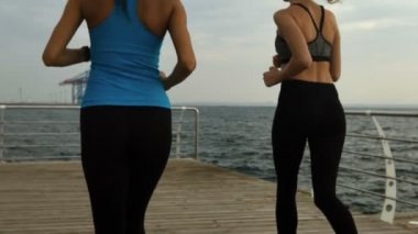 İki ince sportif kadın sahil koşu.