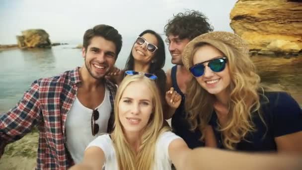 Girato di un gruppo di amici che si fanno un selfie sulla spiaggia — Video Stock