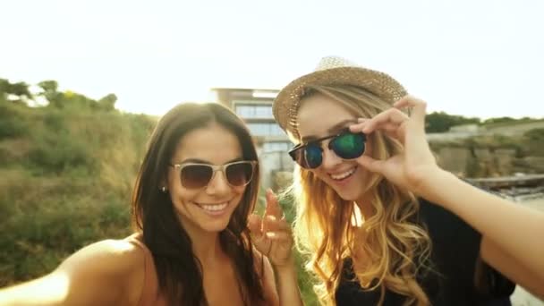 Dos hermosas chicas tomando selfies . — Vídeo de stock