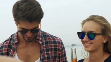 Arkadaşlar bira içme güneş gözlüğü takıyor.