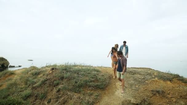 Zwei Paare gehen am Strand spazieren. — Stockvideo