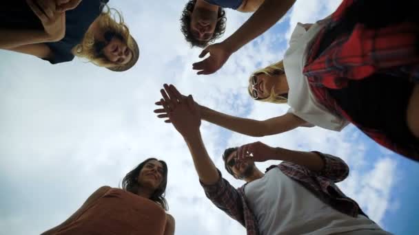 Shot van een groep jonge vrienden hun handen samen stapelen — Stockvideo
