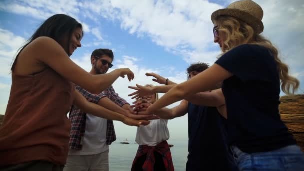 Shot van een groep jonge vrienden hun handen samen stapelen — Stockvideo