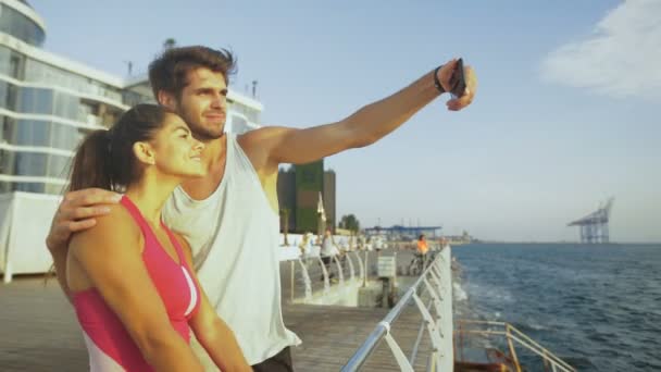 年轻英俊的男子和他美丽的女人在早上慢跑后采取拍照. — 图库视频影像