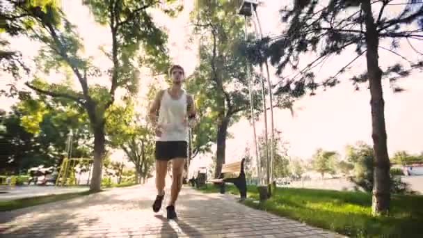 Hombre guapo activo entrenando para maratón en hermoso parque . — Vídeos de Stock