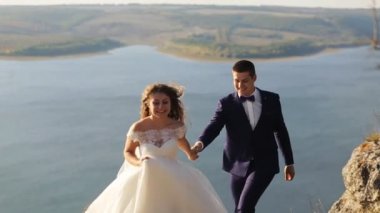 Dağlar ve günbatımı manzara gölde poz muhteşem Düğün çifti.