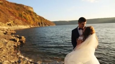 Çekici genç gelin pitoresk yerde yakışıklı kocası ile sarılma.