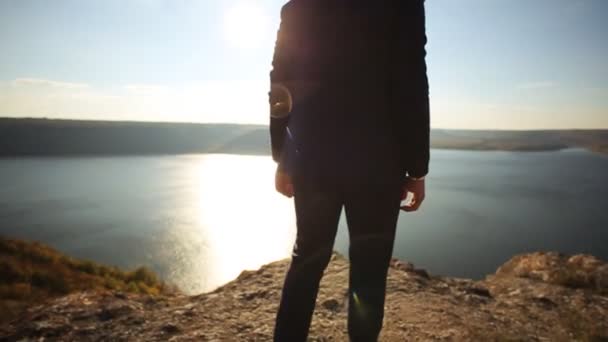 Młody przystojny Grooma noszenie elegancki fikuśnego chodzenie na wzgórzu góry. — Wideo stockowe