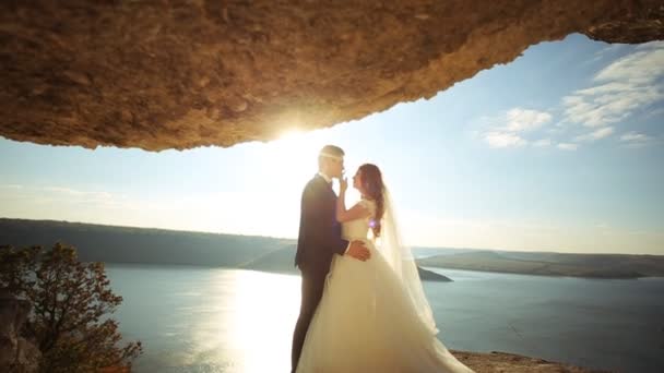 Romantik damat çekici genç eşi güzel bir doğal arka planda sarılma. — Stok video