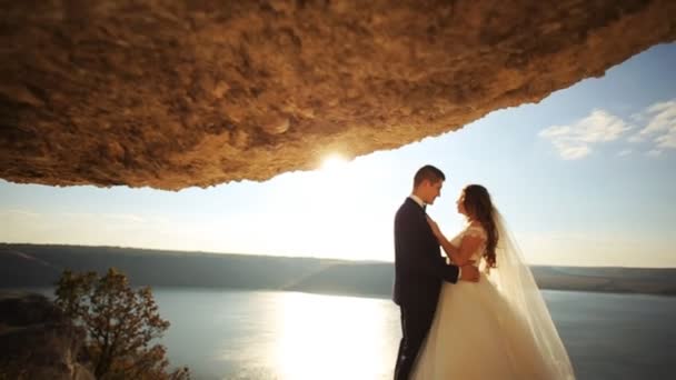 Romantik damat çekici genç eşi güzel bir doğal arka planda sarılma. — Stok video