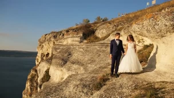 Pareja romántica cogida de la mano mientras camina por la montaña en el campo . — Vídeo de stock