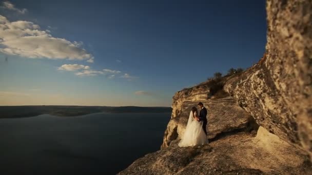 Kissing wedding couple staying over beautiful landscape in the mountain. — Stock Video