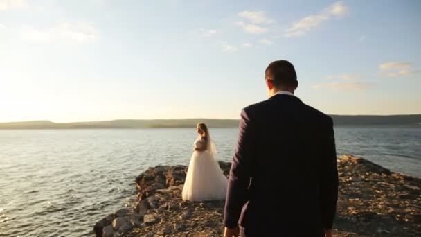 Schönes Hochzeitspaar küsst und umarmt sich auf dem Gipfel des Berges. — Stockvideo