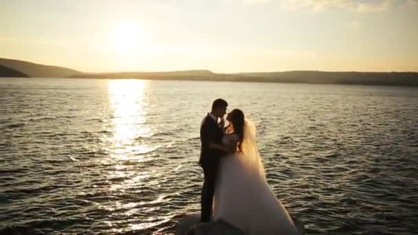 Silueta de una pareja feliz amorosa abrazándose en el fondo del sol poniente  . — Vídeo de stock