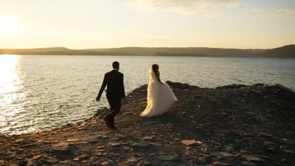 Giovane sposa felice in esecuzione dal suo bel sposo, ma lui la cattura e baciare sulle labbra . — Video Stock