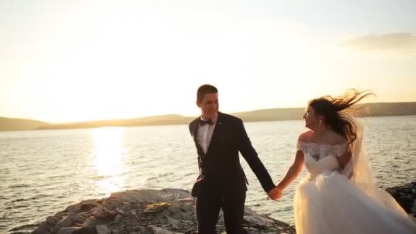 Happy gorgeous smiling bride running and having fun with elegant groomat mountains with amazing view. — Stock Video
