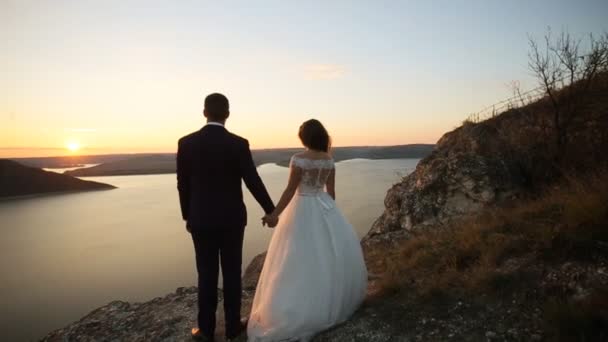 Beau couple de mariage aimant rester sur la montagne et regarder coucher de soleil . — Video