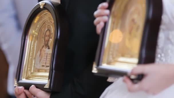 Matrimonio nelle tradizioni cristiane in una bella vecchia chiesa. Coppia di icone in possesso — Video Stock