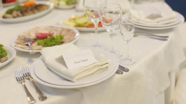 Свадебный стол, полный вкусной еды и маленьких открыток с именами гостей — стоковое видео