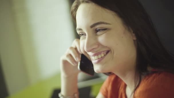 Slow motion comment jeune femme brune parlant au téléphone et souriant . — Video