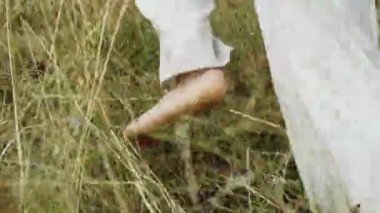 Genç adam açık havada çalışır. Yalınayak genç adam beyaz alanı koşuyor