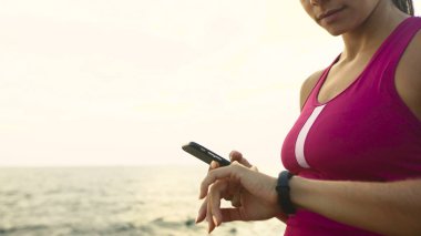 Ciddi genç aktif kadın çalışan saati on mil kontrol.