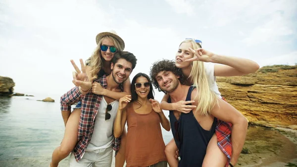 Shot van een groep jonge vrienden genieten van een dag op het strand — Stockfoto