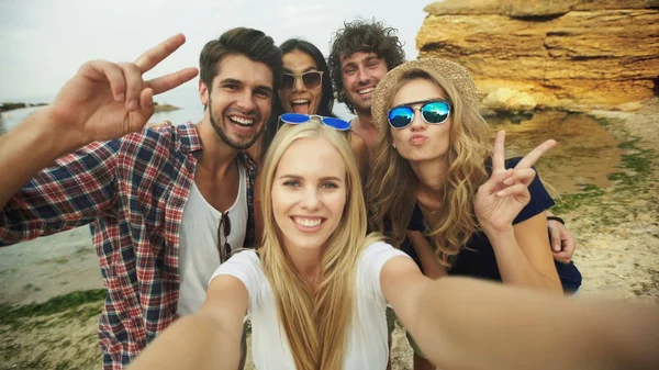 Fotografía de un grupo de amigos tomando una selfie en la playa — Foto de Stock