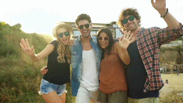 Bir grup arkadaşıyla kumsalda eğleniyor kadeh