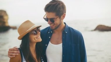 İki genç gülümseyen insanlar sahilde poz komik güneş gözlüğü.