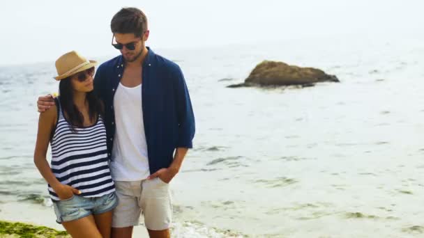 Lachende jonge vrouw en haar grappige aantrekkelijke vriend poseren op de camera, terwijl rusten op het strand. — Stockvideo