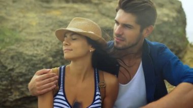 Güzel ince gülümseyen kadın bakım yakışıklı sevgilisi ile bir taş üzerinde oturuyordu.