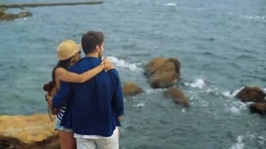 Güzel çift ayakta Taştaki ve ağır Rüzgar tarafından yapılan dalgaları seyretmekten.