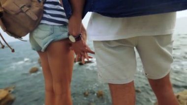 Elele, denize yakın bir taş üstünde kalan iki genç insanın yakın çekim.