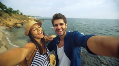 Sahilde kalan kız arkadaşı, selfie resmini poz süre öpüşme gülümseyen yakışıklı genç.
