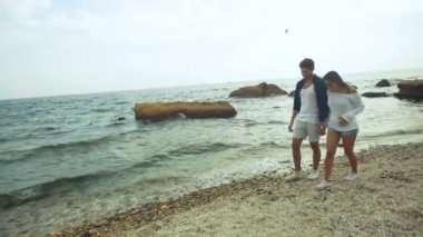 Birbirlerinin ellerini tutarak güzel Sahilde yürüyüş şık mutlu çift.