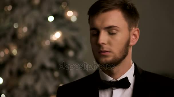 Handsome young man wearing stylish suit , posing on camera on Chistmas time. — Stock Video