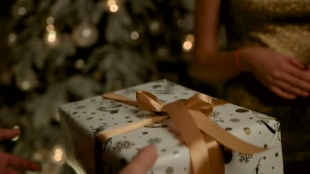 Gelukkig knap man gifting een geschenk in wit en goud gekleurde vak voor zijn mooie dame. — Stockvideo