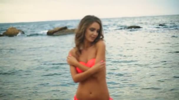 年轻的性感模特抚摸她美丽的身体和相机在海滩上摆姿势. — 图库视频影像