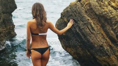 Güzel Bayan su Sahilde yürürken siyah beyaz bikini giyiyor.