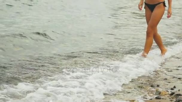 Close up van vrouwelijke lopen op het verlaten strand. — Stockvideo