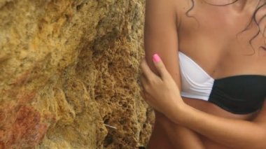 Şehvetli tabaklanmış Bayan seksi mayo güzel taşlı sahilde poz üzerinde.