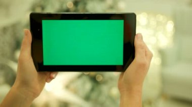 Tablet yeşil yeşil ekran dokunmadan eller Close-Up Chroma Key ekran. Yakın çekim. Hareket izleme. Vertical.with Noel dekorasyon arka plan bulanıklık
