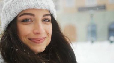 Poz ve karlı şehir arka plan üzerinde kamera flört çekici güzel Bayan