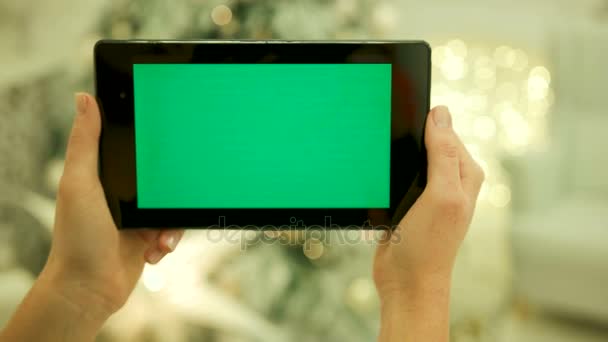 Close-up de mãos femininas tocando tela verde no tablet Tela verde Chroma Key. Fecha. Movimento de localização. Vertical.with borrão natal decoração fundo — Vídeo de Stock