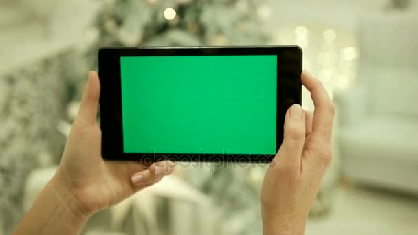 Primer plano de las manos femeninas tocando la pantalla verde en la tableta Pantalla verde Chroma Key. De cerca. Movimiento de rastreo. Vertical.with difuminación Navidad decoración fondo — Vídeos de Stock