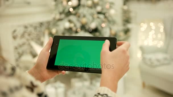 Primer plano de las manos femeninas tocando la pantalla verde en la tableta Pantalla verde Chroma Key. De cerca. Movimiento de rastreo. Vertical.with difuminación Navidad decoración fondo — Vídeos de Stock