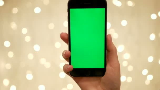 Frau Hand halten Smartphone auf abstrakten verschwommenen Bokeh des hellen Hintergrunds.. Green Screen Chroma-Taste. Nahaufnahme. Tracking-Bewegung. vertikal — Stockvideo