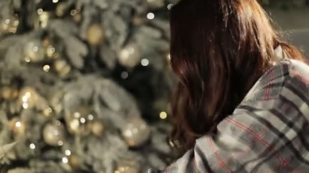 Junge glückliche überraschte Frau öffnet Geschenkbox neben geschmücktem Weihnachtsbaum — Stockvideo
